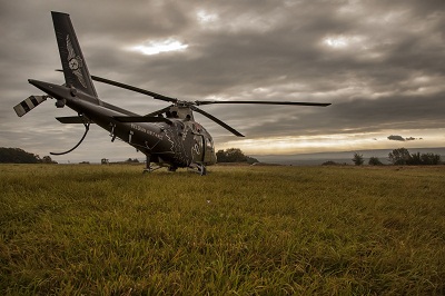 Green Blade helicopter on ground under clouds