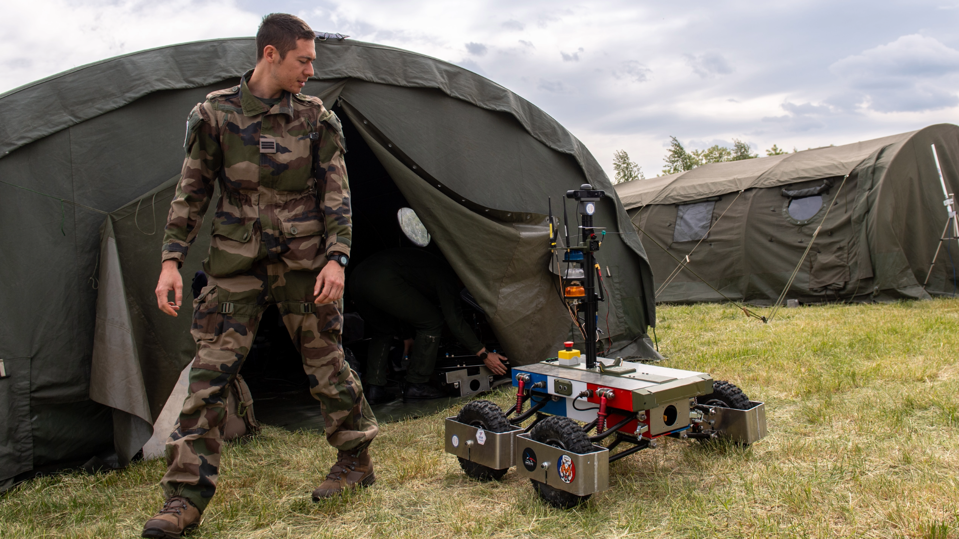 Soldier walking next to an unmanned ground vehicle at European Defence Innovation Days